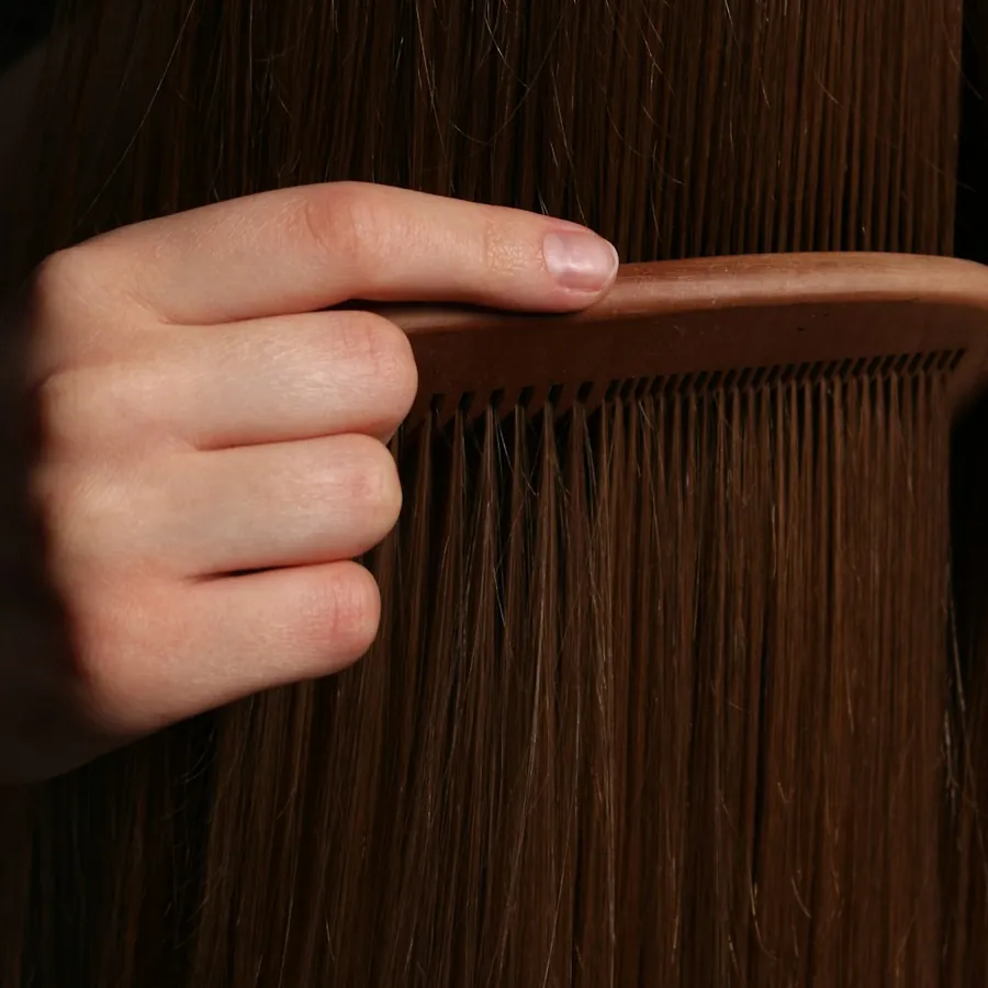 A comb drawn through long brown hair
