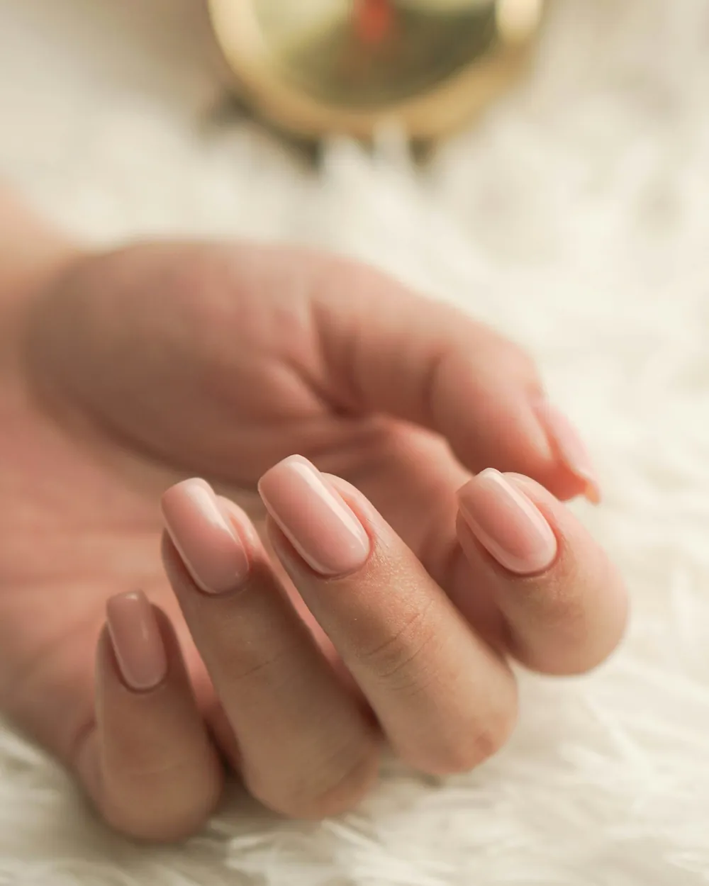 A hand with soft pink manicured nails